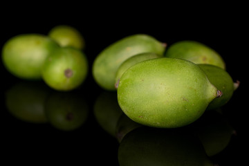 Lot of whole hardy green kiwi isolated on black glass