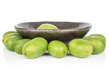 Lot of whole hardy green kiwi in glazed bowl isolated on white background