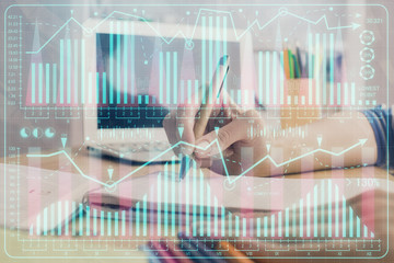 Financial forex charts displayed on woman's hand taking notes background. Concept of research....