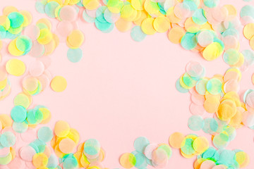Colorful paper confetti on pink background. Celebration concept. Flat lay. Top view.
