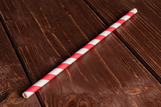 One Whole Red Paper Straw On Brown Wood