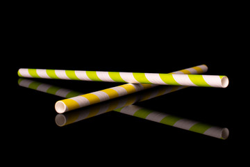 Group of two whole crossed paper straw isolated on black glass