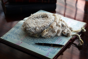 Barrister’s wig on open book with pen