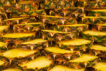 Pineapple juicy yellow slices background. Top view.