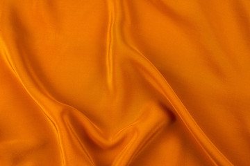 Golden silk or satin luxury fabric texture can use as abstract background.