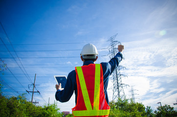 electrician proudly raises his hand at the electric pole on a blue background.