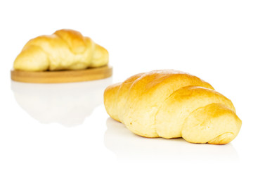 Group of two whole sweet golden mini croissant on bamboo coaster isolated on white background
