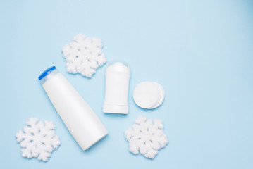 Set of cosmetic products on blue background, flat lay with space for text. Winter body care