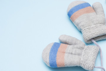 gray child mittens on blue background, copy space. winter cloth