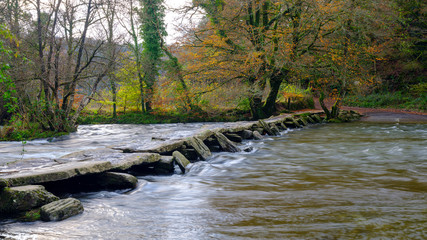 Tarr Steps with a full flowing river Barle and autumn colours, Exmoor