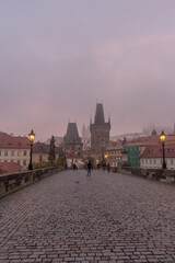 Naklejka premium Landscapes on Charles Bridge with Bridge Tower and Statues at sunrise in a foggy morning, Prague, Czech Republic, Europe