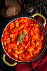 Pollock in tomato marinade with onions and carrots in a round shape, selective focus, top view