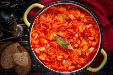 Pollock in tomato marinade with onions and carrots in a round shape, selective focus, top view