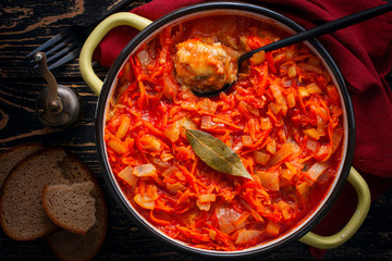 Pollock in tomato marinade with onions and carrots in a round shape, selective focus, top view
