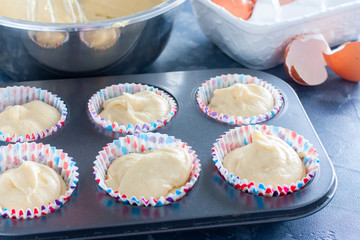 Raw muffins in a metal mold before baking, horizontal