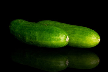 Group of two whole fresh green baby cucumber isolated on black glass