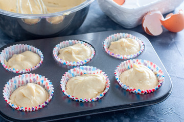 Raw muffins in a metal mold before baking, horizontal