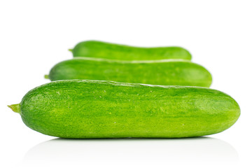 Group of three whole fresh green baby cucumber in line isolated on white background