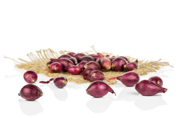 Lot of whole small red onion bulb on natural sackcloth isolated on white background