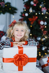 Happy excited girl child holding christmas gift box.
