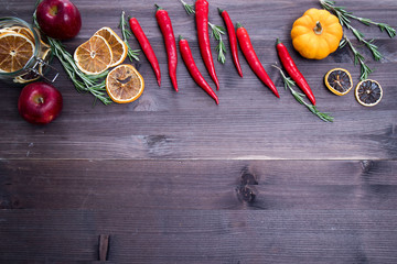 pumpkins, apple and dry slice of orange, chili pepper, top view on the brown wooden background , web banner with copy space