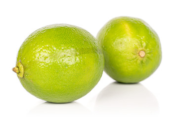 Group of two whole sour green lime isolated on white background