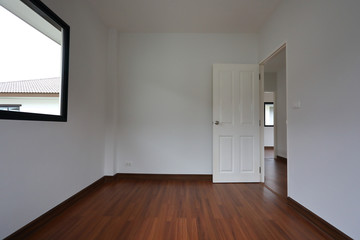 interior design empty room with white wall and wooden laminate floor in new residential house