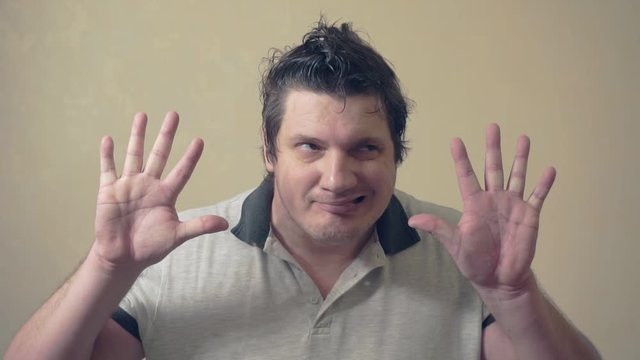 funny emotional man shows various grimaces resting against an invisible wall.cheerful middle aged male.video portrait