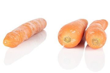 Group of three whole arranged fresh orange carrot isolated on white background