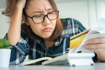 Confused portrait young woman holding credit cards having problem online payment with credit card making rejected unsecure online payment. credit card debt payment