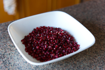Bowl of freshly pealed and cleaned Pomegranates sitting on a kitchen top