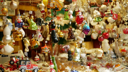 Christmas market stall or stand with tree decorated ornaments products star, toys, balls, garlands, various, fish, ornaments, cars, and animals are hanged pine needles. decoration hanging traditional
