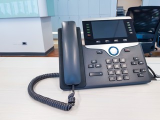 IP phone device on work office table desk background. Communication Technology to connect and call...