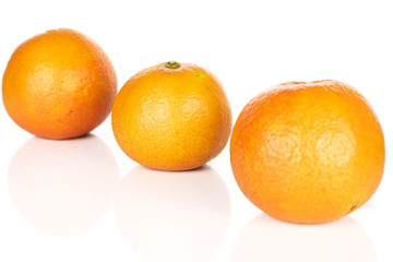 Group of three whole fresh orange mandarin diagonal isolated on white background