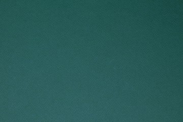 Dark green colored paper texture background.