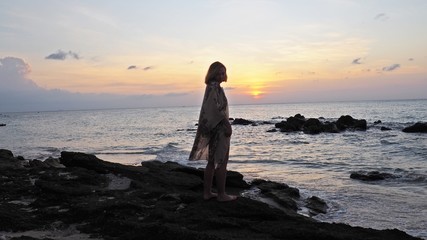 girl meditating practising yoga at the beach kimono thailand sunset