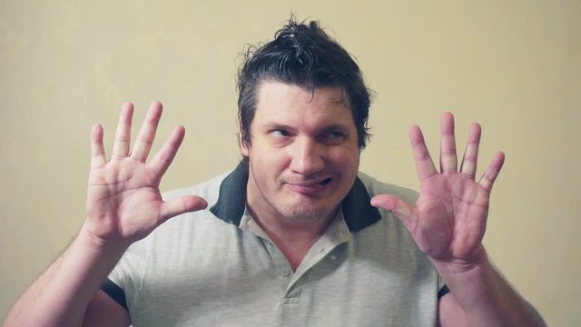 funny emotional man shows various grimaces resting against an invisible wall.cheerful middle aged male.video portrait