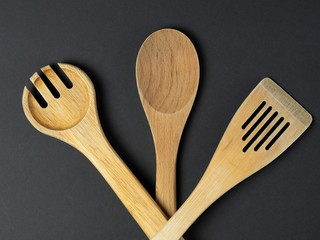 A variety of Cutlery and natural wood laid out on a black background. Concept of renewable sources...