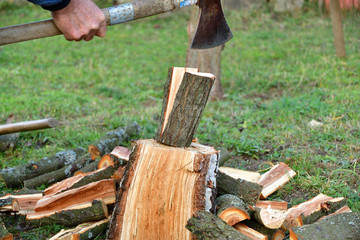 Detail on an ax as it cuts logs of wood into smaller pieces