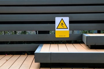Warning signs to step up or down carefully on the metal slat wall next to the stairs.