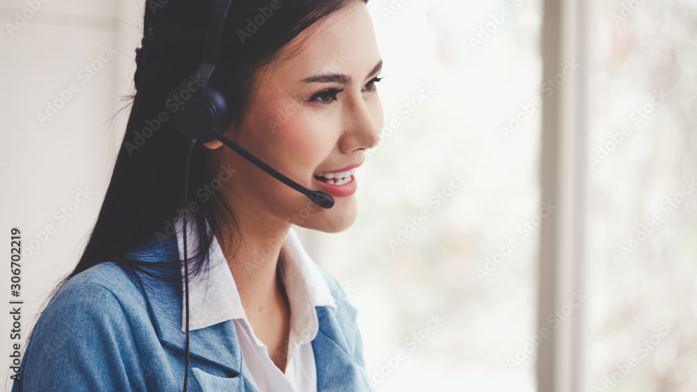 Poster customer support agent or call center with headset works on desktop computer while supporting the cu