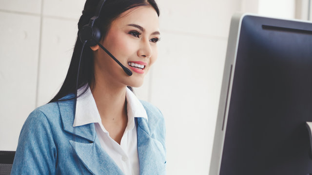 Customer Support Agent Or Call Center With Headset Works On Desktop Computer While Supporting The Customer On Phone Call. Operator Service Business Representative Concept.