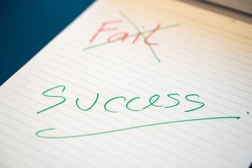 Fild text with a hand with a red pen And crossed out with a green pen on the notebook. Success message by hand with a green pen below the fail. The concept of ​​not giving up on failure.