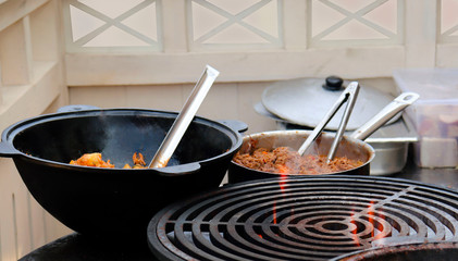 The process of cooking on the grill. Cooking chicken legs on the fire. Picnic in nature.