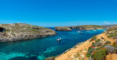 Fototapeta na wymiar Stone cliffs on the blue lagoon of the island of Comino and Gozo Malta. Mediterranean Sea