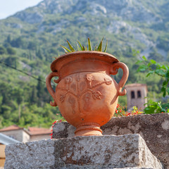 Obraz premium the old brown vase with figures on the street of Perast, Montenegro