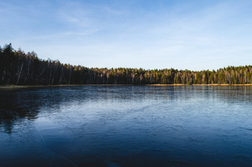 Landscape freezing of the lake in early winter on a sunny day.