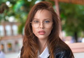 Close up portrait of a beautiful woman in eyeglasses outdoor.