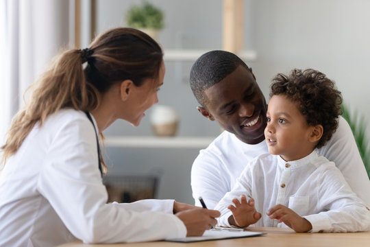Cheerful young female pediatrician and black father listening to patient.