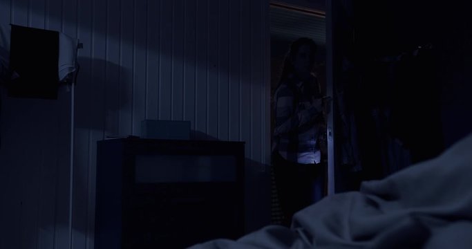 Cinematic. Female burglar examines the chest of drawers.